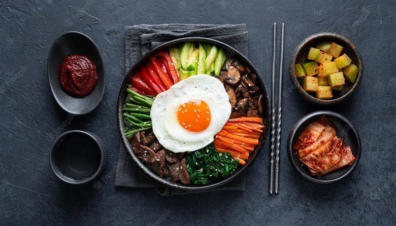 Bát tương ớt gochujang để riêng bên cạnh bát Bibimbap chưa trộn