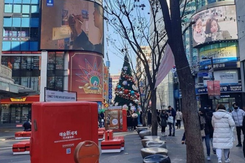  Du khách dùng điện thoại dịch bảng hiệu tiếng Hàn trên phố Seoul