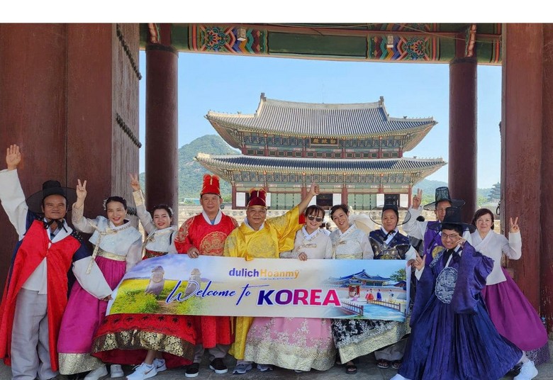 Gia đình nhiều thế hệ đi cùng hướng dẫn viên trước cung Gyeongbokgung