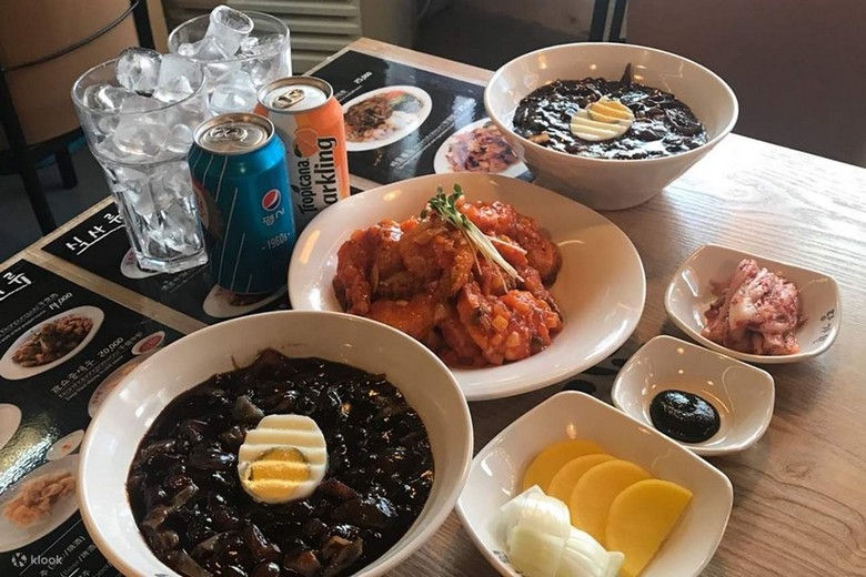 Khách đang trộn và thưởng thức tô mì đen tại một quán ở Myeongdong, Seoul