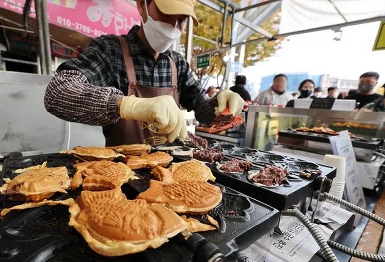 Khách xếp hàng chờ mua bánh cá bungeoppang tại một khu chợ ở Seoul