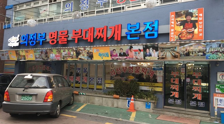 Phố Budae Jjigae Uijeongbu với biển hiệu và cờ cam đặc trưng