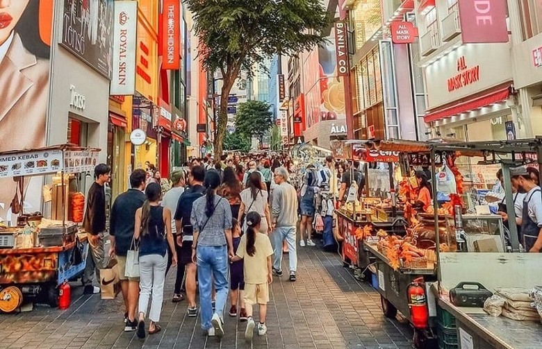 Phố mua sắm Myeongdong đông đúc ban ngày với các cửa hàng san sát