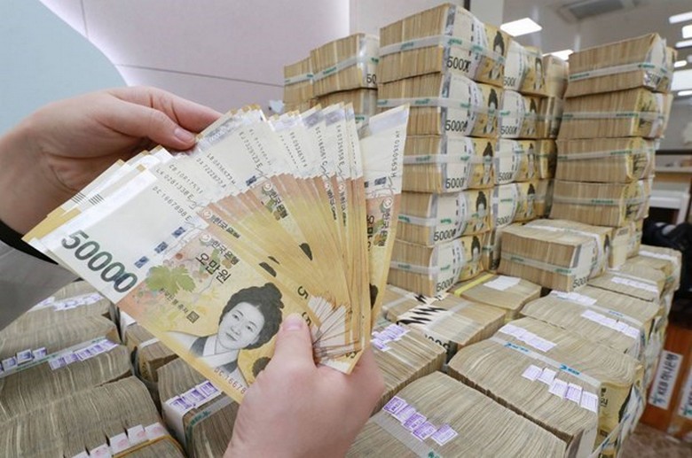Xấp tiền Won Hàn Quốc và tiền Việt Nam đặt cạnh nhau trên bàn