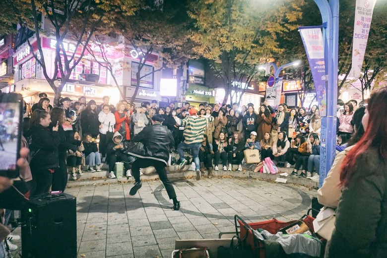 nhóm bạn trẻ xem biểu diễn đường phố tại Hongdae Red Road về đêm